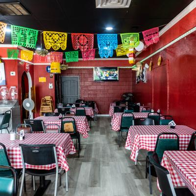Mexican restaurant interior with red-and-white checkered tablecloths and papel picado decorations.