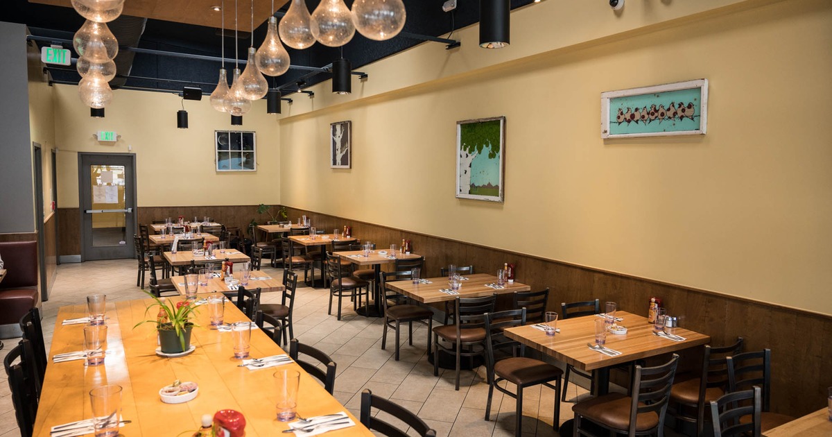 Interior, dining area, wooden top tables, tile flooring, large community table