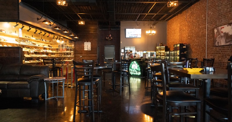 Modern interior, wooden black tables and chairs with nicely lit cigarette shop