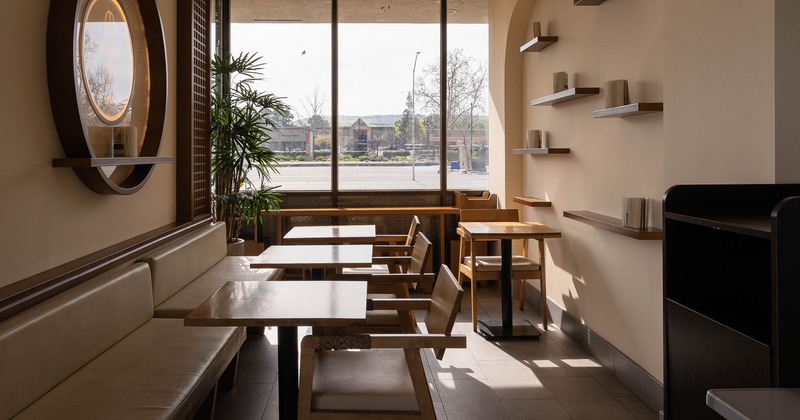 Interior, tables and chairs with large window behind
