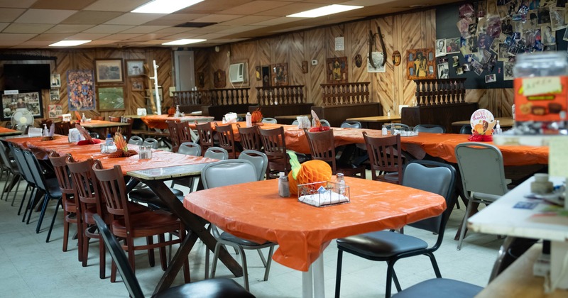 Dining hall with orange tablecloths and autumn decorations
