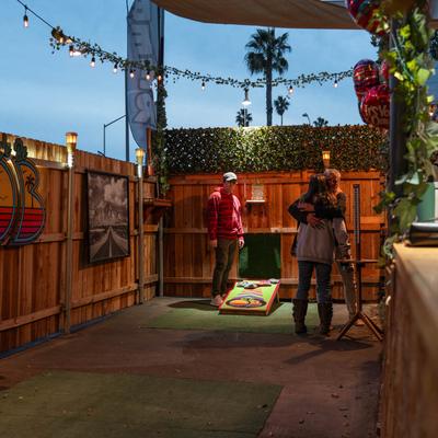 People standing in front of a wooden fence in serene outdoor setting.