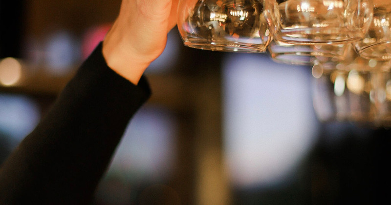Bartender hanging wine glasses