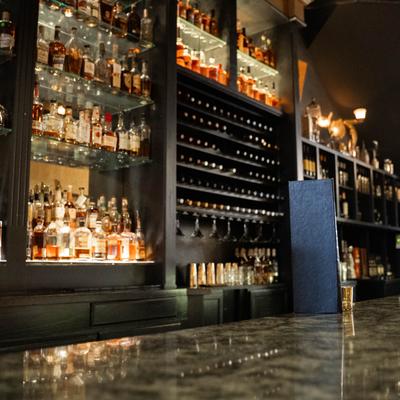 back of the bar looking at the whiskey bottles.