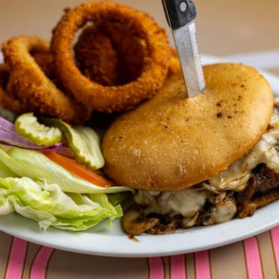 Mushroom burger served with onion rings.