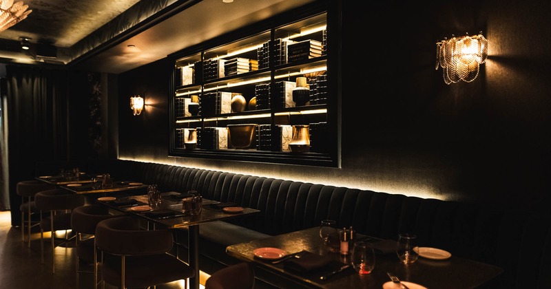 Interior, seating area, long padded banquette bench with tables and chairs, ready for guests