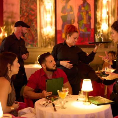 Guests dining together at a table inside an Calle Dragones restaurant dining room..