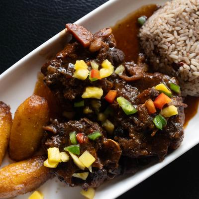 Oxtail served with sweet plantains and rice.