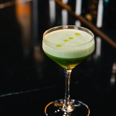 Green cocktail served in a stemmed glass.