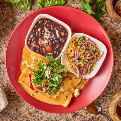 Enchiladas in lobster cream sauce, served with black beans, and roasted corn.
