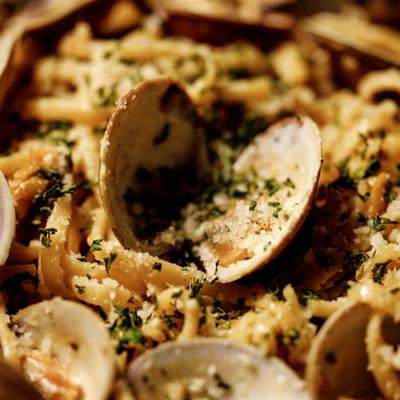 Linguini alle Vongole featuring clams, herbs and grated cheese, close-up.