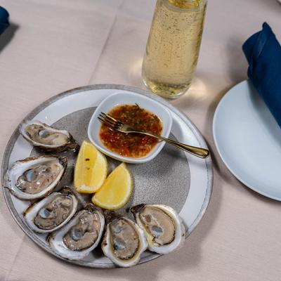 East Coast Oysters with lemon wedges and sun dried tomato mignonette sauce.