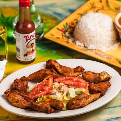Boneless chicken served with a salad and sides of rice and beans.