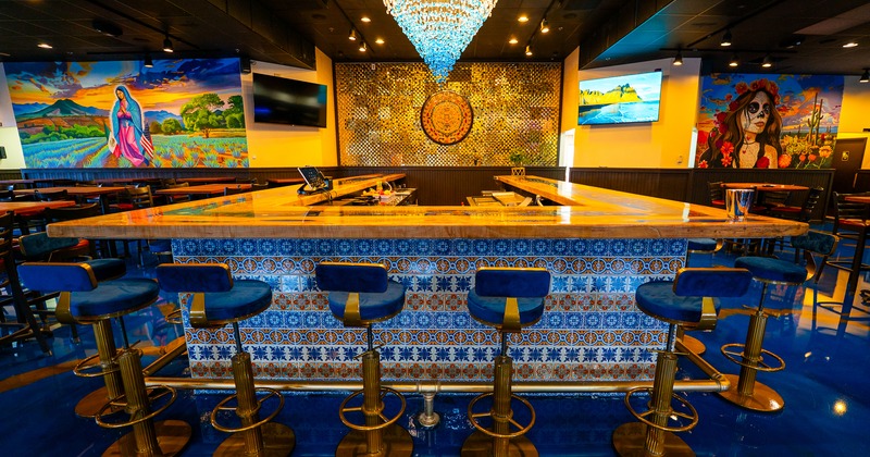 Bar, stools, chandelier and tv screens above