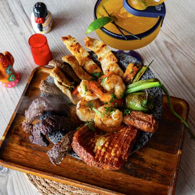 Molcajete bowl with grilled chicken, shrimp, steak, and sausage.