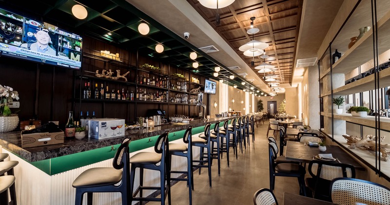 Interior, dining area, bar with bar stools, large drinks shelves, TV on the wall