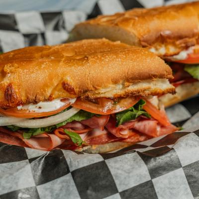Sub sandwich layered with deli meat and vegetables.
