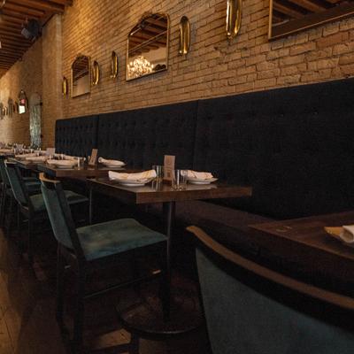 Interior, banquette seating by a wall with set tables