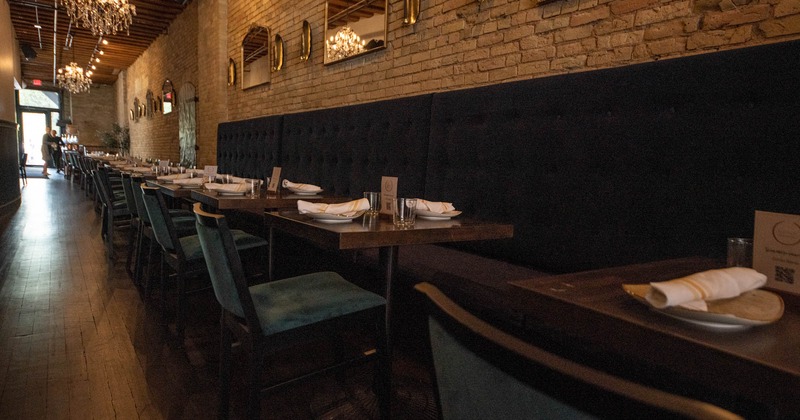 Interior, lined up set tables with chairs and high back wall seating