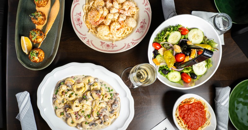 Assortment of dishes and white wine on a table, overhead view