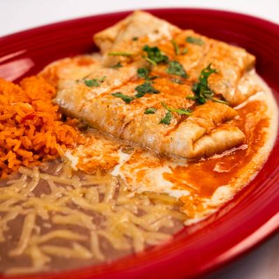 Deep fried chicken burrito,  with rice and refried beans on the side.