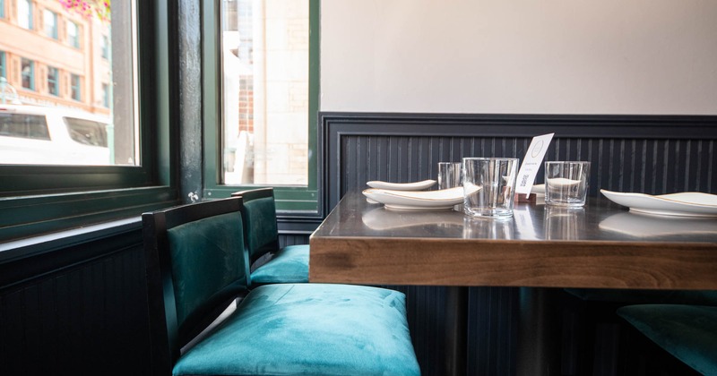 Interior, dining table by a window with plates and glasses