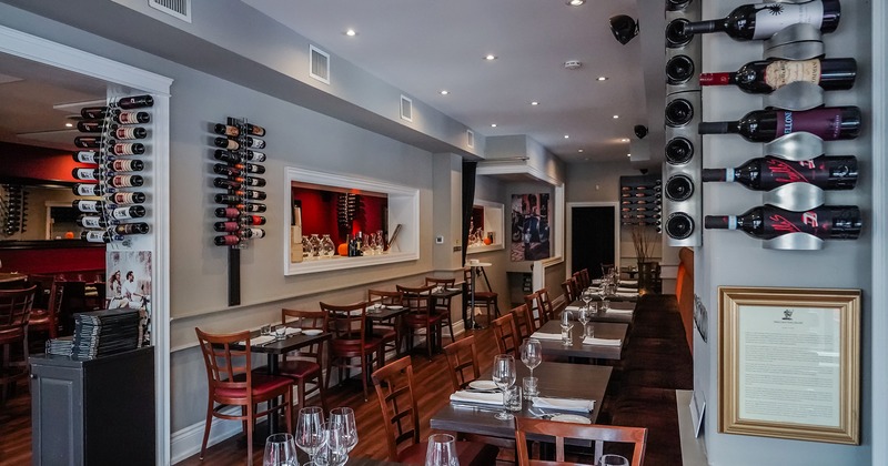 Restaurant interior, dining area with set tables, wall-mounted wine racks