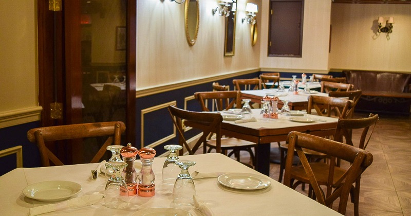 Interior, seating area, tables ready for guests, glass door on  the left