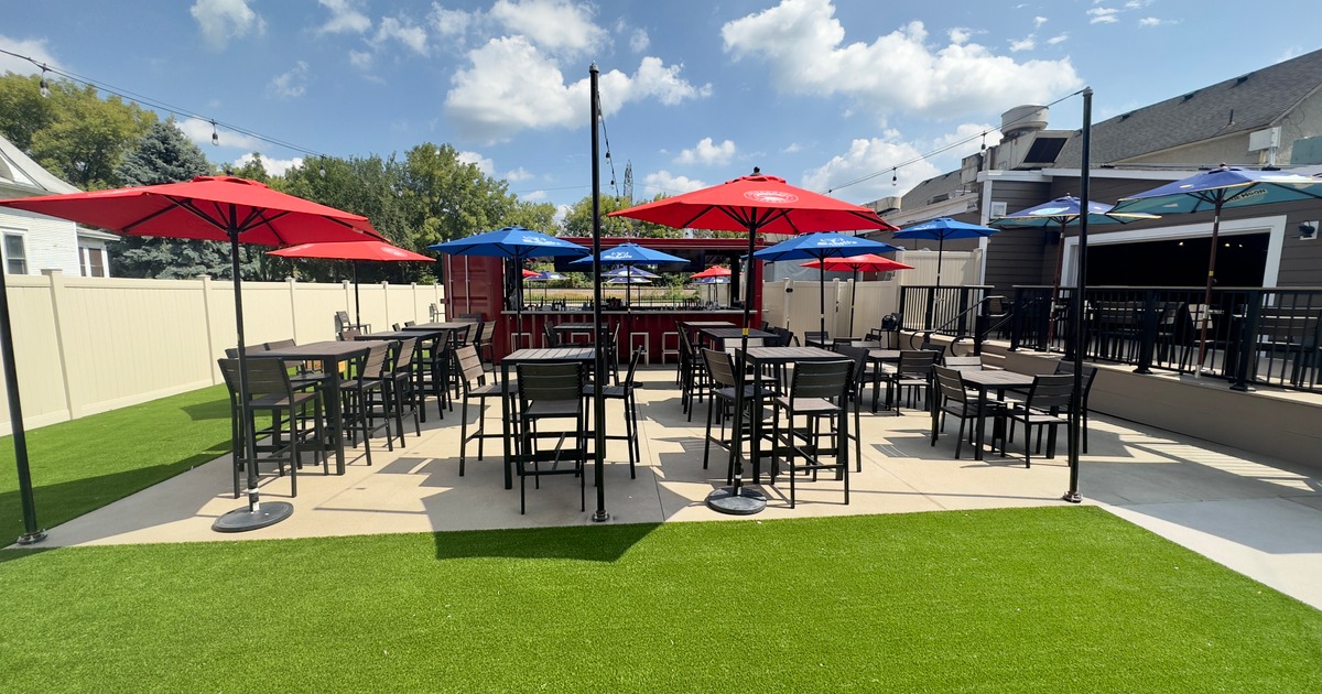 Exterior, partially covered seating area, high seating tables with chairs, cut lawn