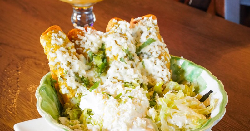 Flautas, served with lettuce, sour cream, and cheese