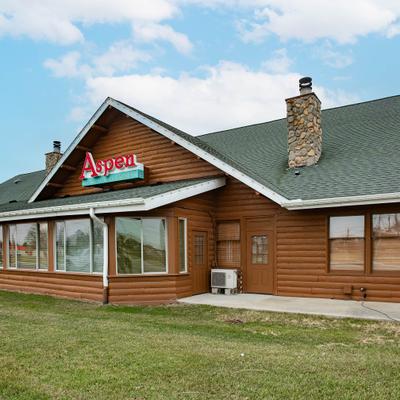 The restaurant exterior with a wooden facade and grass lawn.