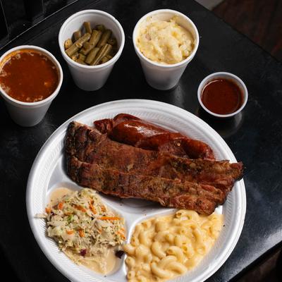 Steak and sausage with coleslaw, mac and cheese, accompanied with assorted sides.