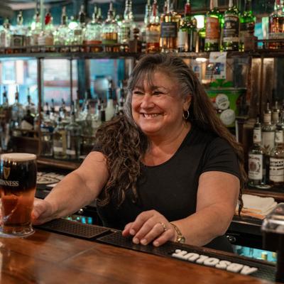 A bartender serving a pint of beer.