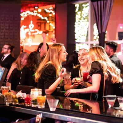 Interior, bar area, guests enjoying drinks and conversing.