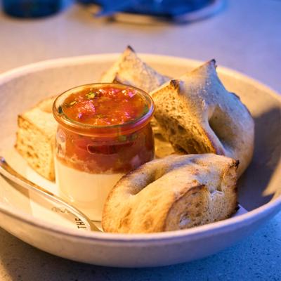 Toast wedges served with a jar of jam and ricotta.