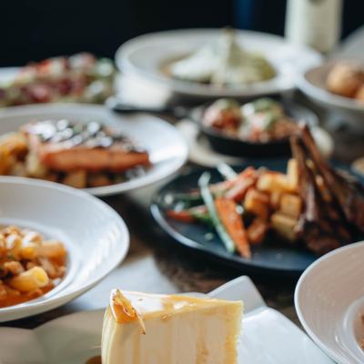 Multiple plates with assorted grilled meats and vegetables.
