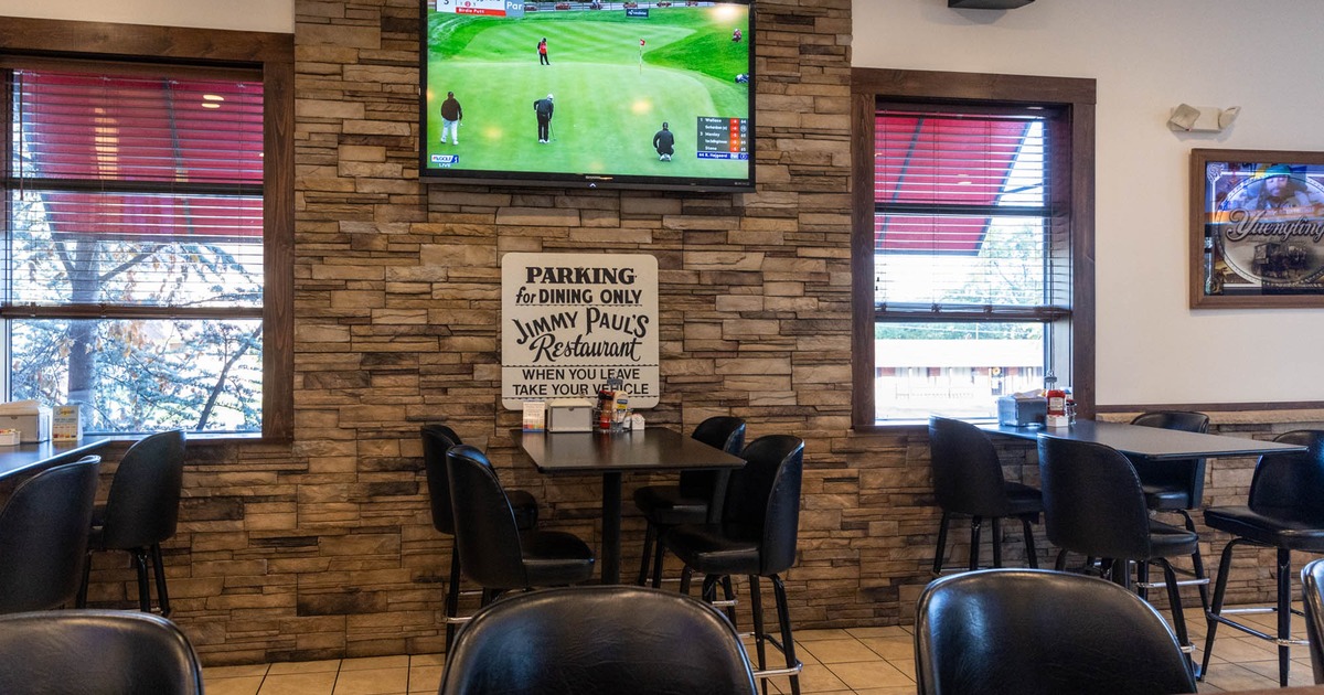 Interior, tables with chairs, big TV screen on the wall