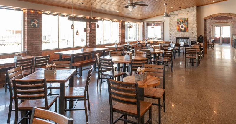 Interior, open space seating area, tables with chairs, large window area, ceiling fans