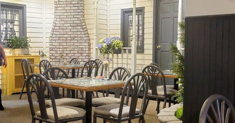 Interior, dining area, table for two, artificial green wall with neon restaurant logo signage