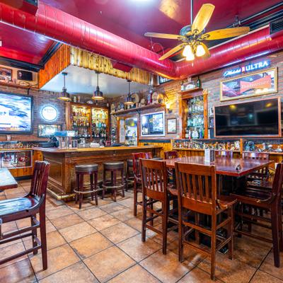 Cozy bar interior with wooden furniture and warm lighting.