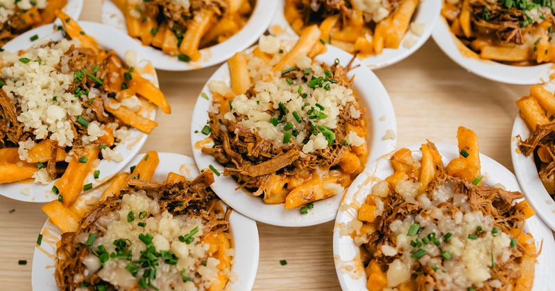 Numereus small servings of loaded fries topped with shredded pork and cheese