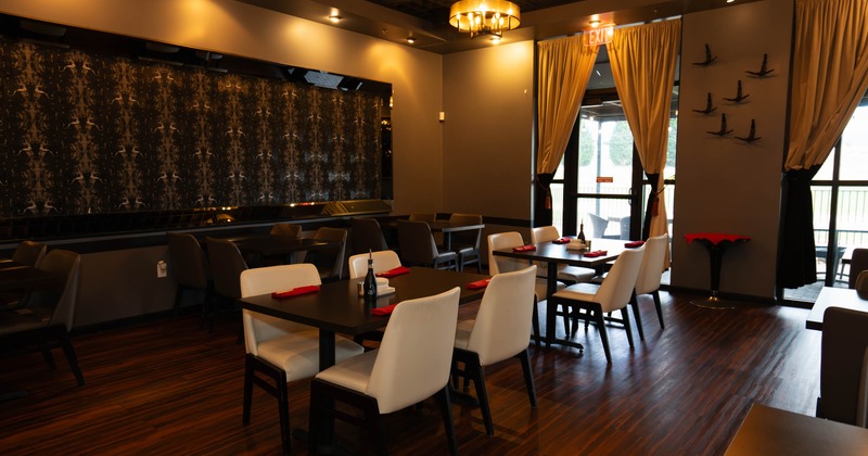 Interior of a modern restaurant with wooden tables, leather chairs, and ambient lighting