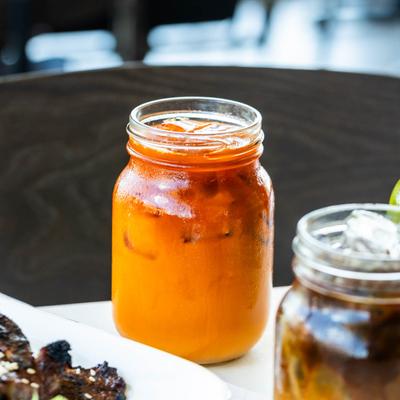 Thai tea jar with beverages and food, close up