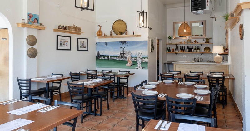 Interior, set tables in dining area with painting on the wall