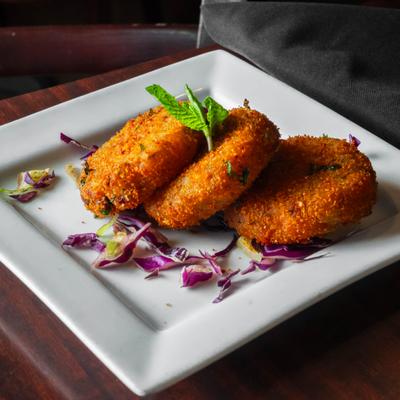Indian fried mashed potato patties with cabbage and mint garnish.