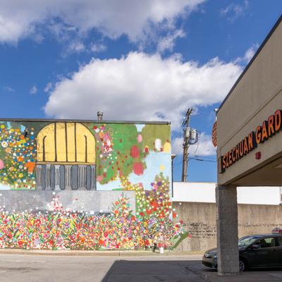 Colorful mural beside restaurant exterior corner wall.