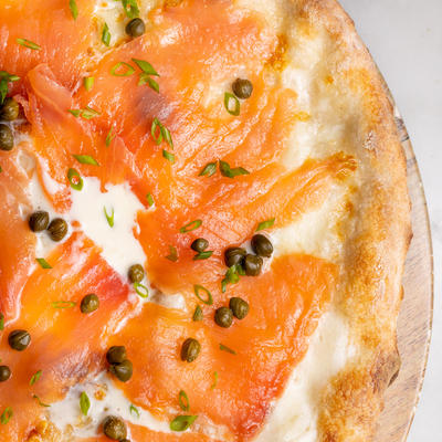 Raw fish pizza with cream, closeup