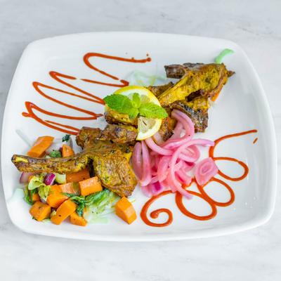 Goat Chops, marinated in spices, with salad.