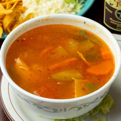 Bowl of Tortilla soup with vegetables.