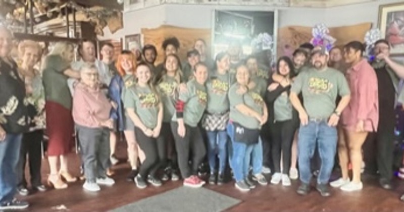 Group photo of staff working "AJ's Feeds The Community" Thanksgiving Event.